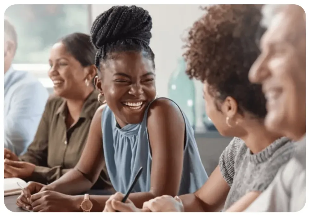 Collègues souriants autour d'une table de réunion